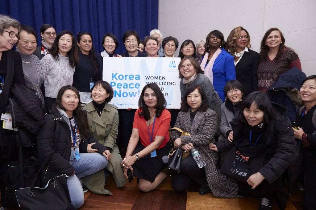 Group of women holding the sign "Korea Peace Now!"