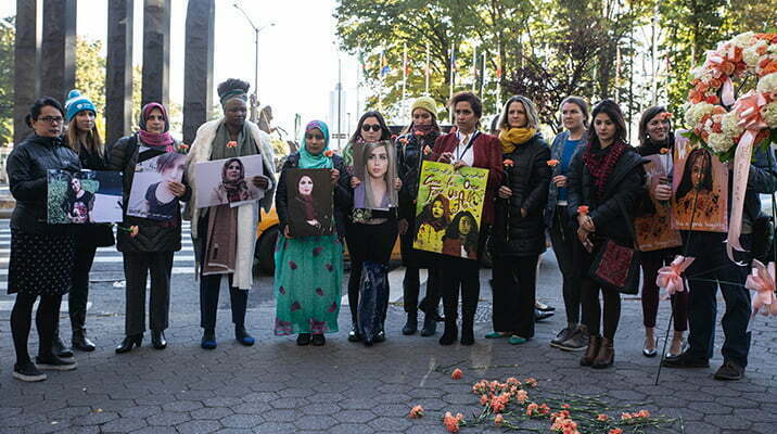 Participants of the vigil for Iraqi Women standing in front of the UN headquarters, remembering Tara Fares, Suaad al-Ali, Rasha al-Hassan, and Rafif al-Yasiri. 