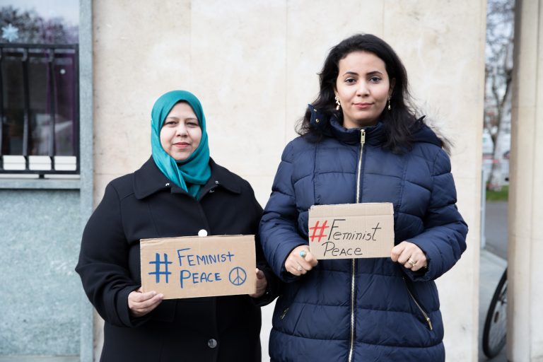 Muna Luqman and Nisma Mansour holding "Feminist peace" signs